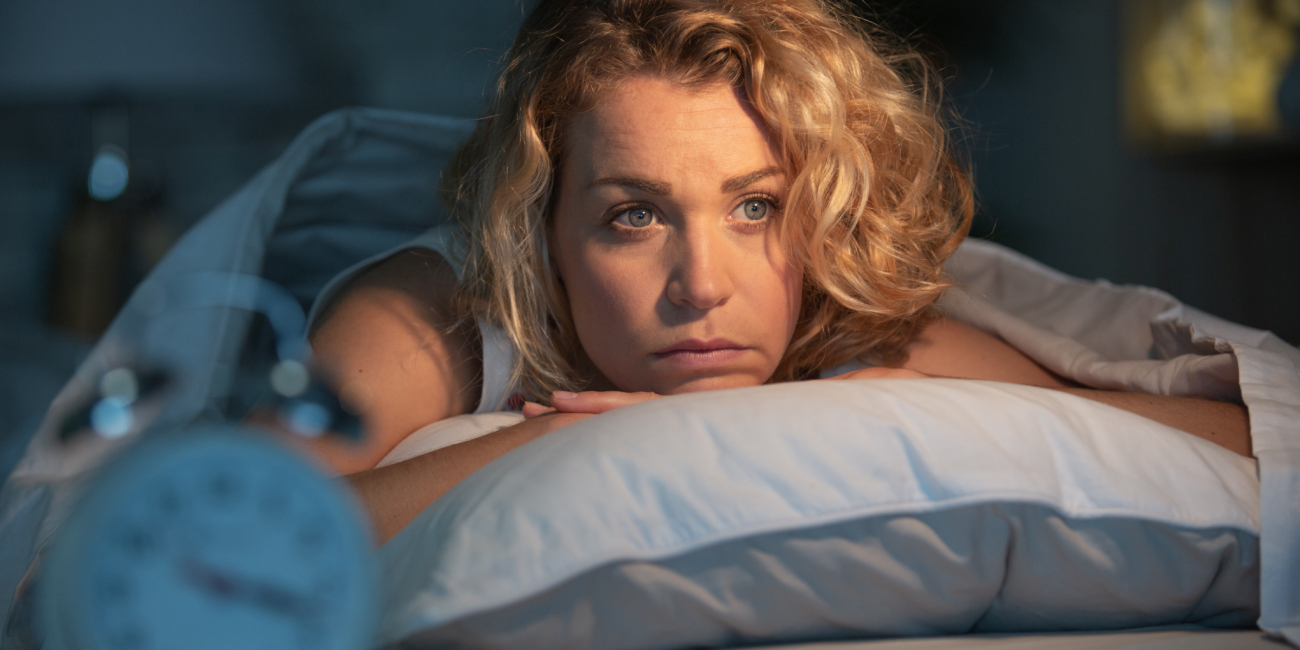 Donna che rimane sveglia la notte a causa della sua insonnia (non riesce ad addormentarsi)