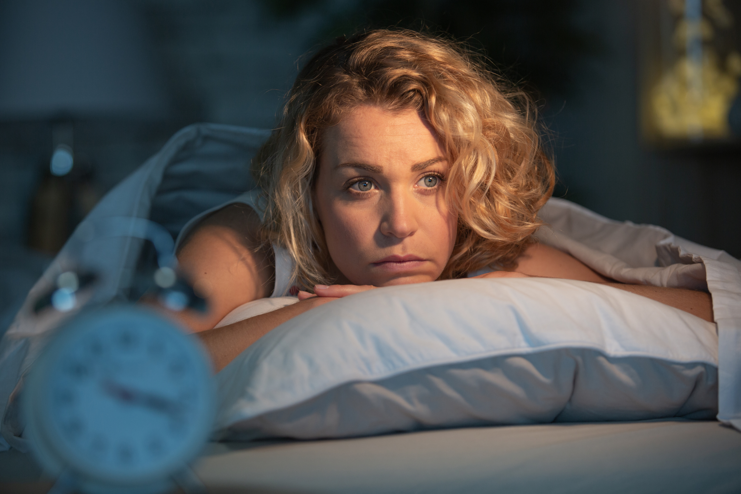 Donna che rimane sveglia la notte a causa della sua insonnia (non riesce ad addormentarsi)